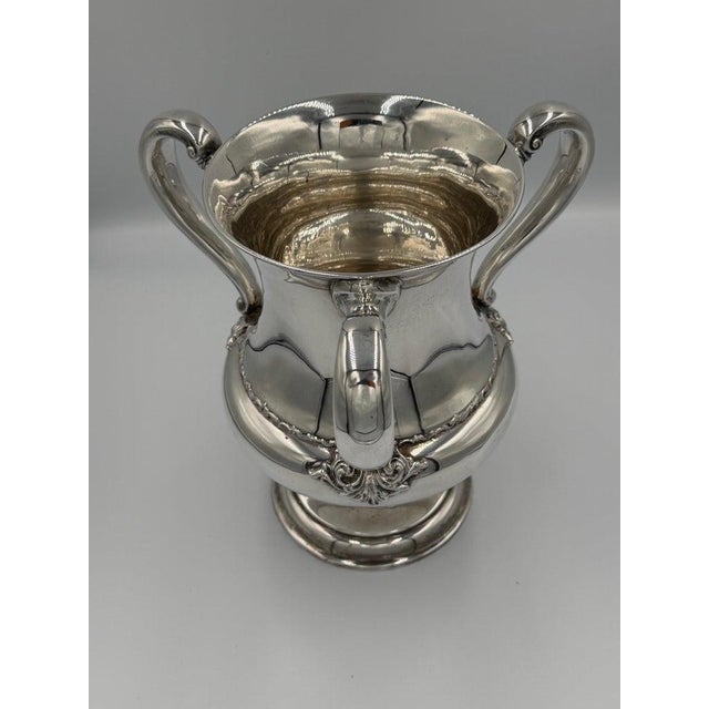 A commanding example of American silver craftsmanship, this monumental three-handled loving cup in made of sterling...