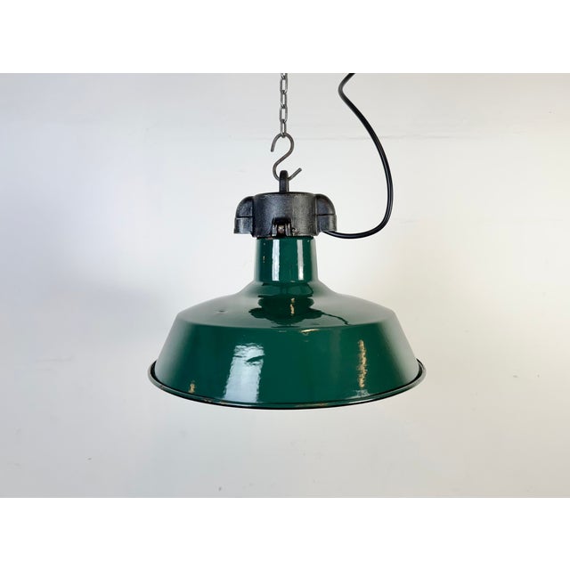 Industrial dark green enamel pendant light made in France during the 1960s. White enamel inside the shade. Cast iron top....