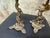 A brass candlestick pair modeled as rearing horses, each rising from a shaped base with a small turned support, scalloped...