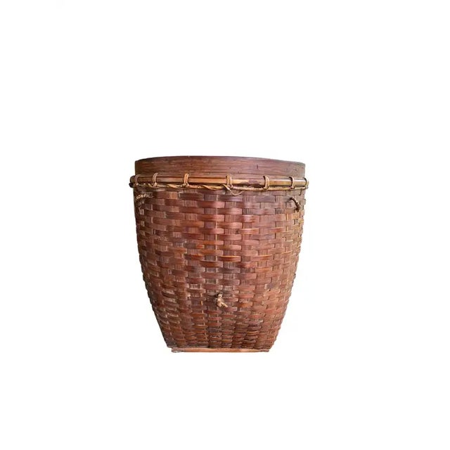 This mid-20th century hand-woven basket originates from the Dayak tribe of Borneo crafted with rattan fibres and an iron...