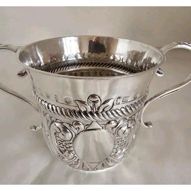 A remarkable Queen Anne period Britannia standard silver porringer, dating to the early 18th century and richly decorated...