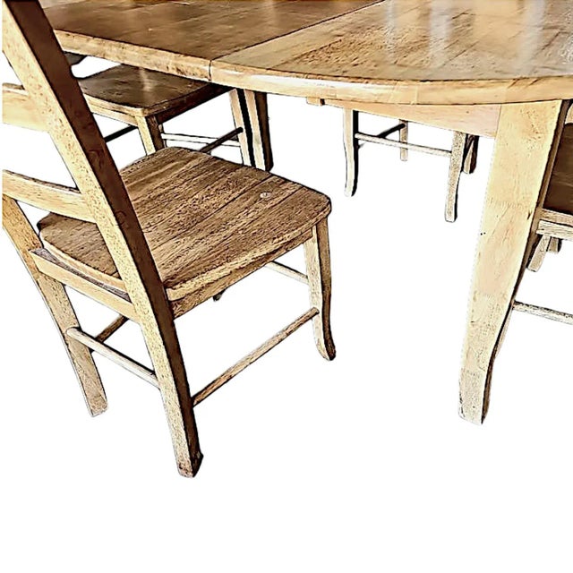 An Amish farmhouse style expandable kitchen dining table and 4 matching 3 rung ladder back chairs. The table is round in...