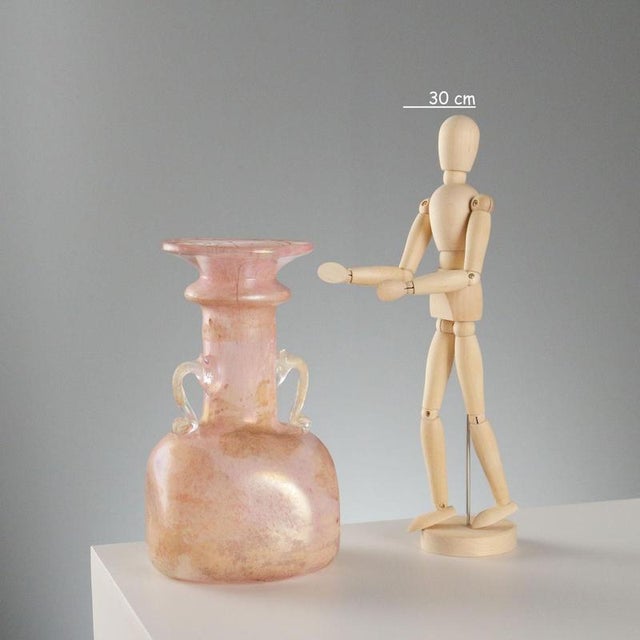 A blown Scavo glass vase in shades of pink, with its distinctive handles and iridescent surface. Scavo glass is a unique...
