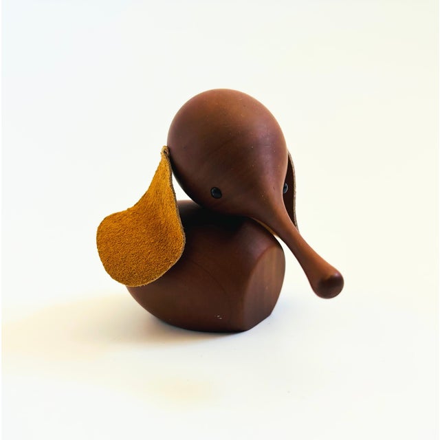 A mid century turned wood figurine in the shape of an Elephant. Adorable stylized features with suede ears and tail. Made...