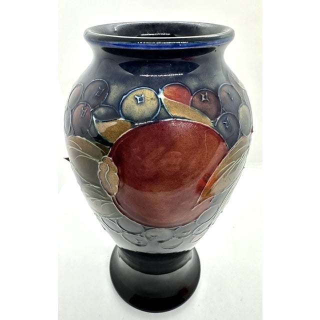 This is a William Moorcroft studio pottery pomegranate vase that measures 9" tall and 4.5" wide. Marked with Moorcroft...