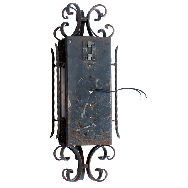 Spanish Revival or Gothic-style hand-forged wrought iron lantern pendant. It features ornate scrollwork with a dark gray...