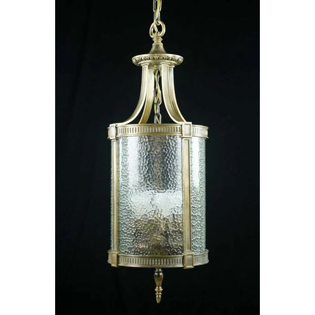 This 1940s hanging lantern exudes timeless charm. Its bronze frame and clear pebbled glass showcase a classic design,...
