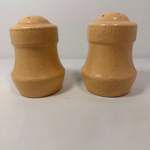 Vintage ceramic salt and pepper shaker set features a charming butterfly and floral motif on a speckled yellow-tan glaze....
