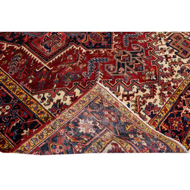 Beautiful Vintage Heriz hand-knotted Wool rug with the red field. This Heriz rug has a multicolor accents in all over...