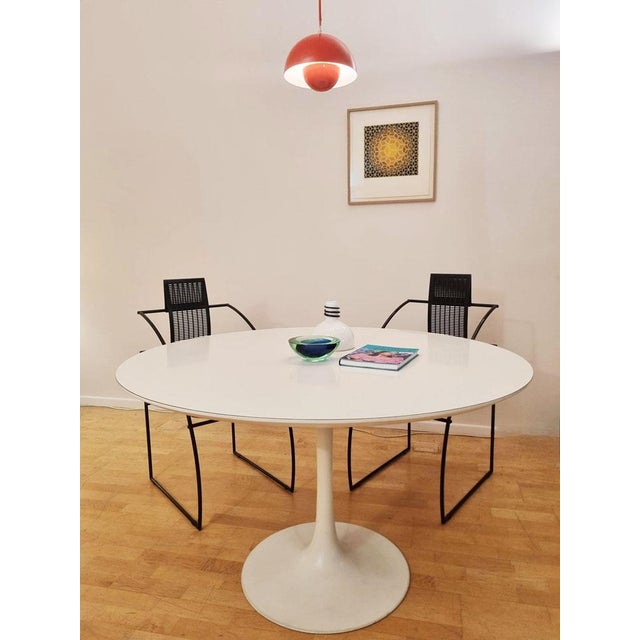 Elegant round table in white laminated wood, with a central tulip pedestal base Designed by Maurice Burke for Arkana (UK),...