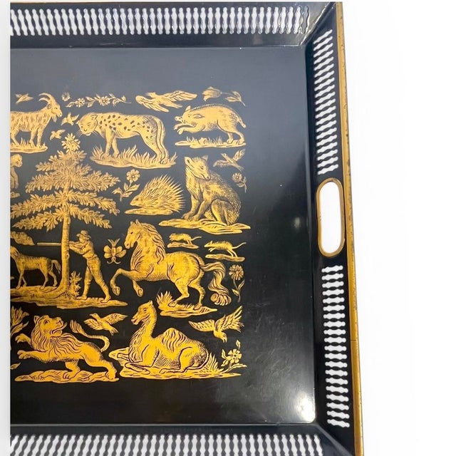 Striking black and gold tole tray featuring an intricate hunt scene motif, inspired by the iconic style of Atelier...