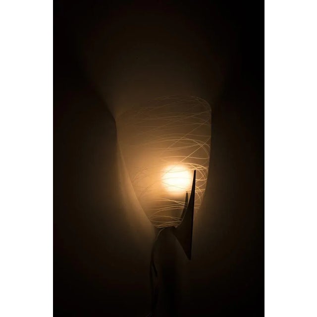 A brass wall lamp with striped glass, in a fair condition. This lamp gives a nice light reflection. Measurements h. 29 cm;...