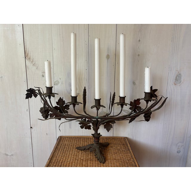 Gorgeous, iron French candelabra depicting grapes, wheat, vine leaves and lilies! This intricate antique piece likely came...