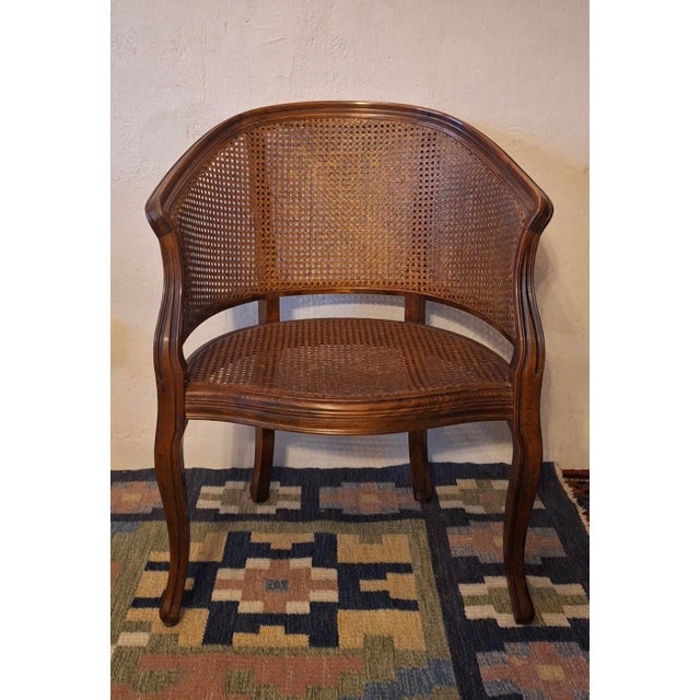 Half-moon rattan and hardwood armchair dating from the early 20th century. Beautiful colour.