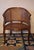 Half-moon rattan and hardwood armchair dating from the early 20th century. Beautiful colour.