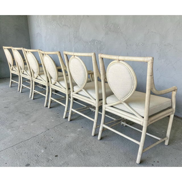 Elegant set of six rattan dining armchairs by Ficks Reed, featuring distinctive teardrop-shaped upholstered backs and...