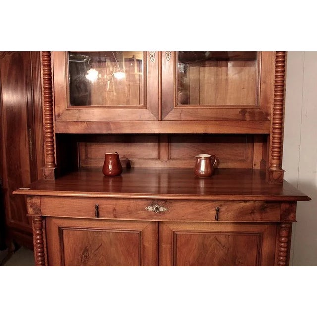 Two-body walnut sideboard with niche in the middle. The upper part opens with 2 glass doors, the lower part with 2 solid...