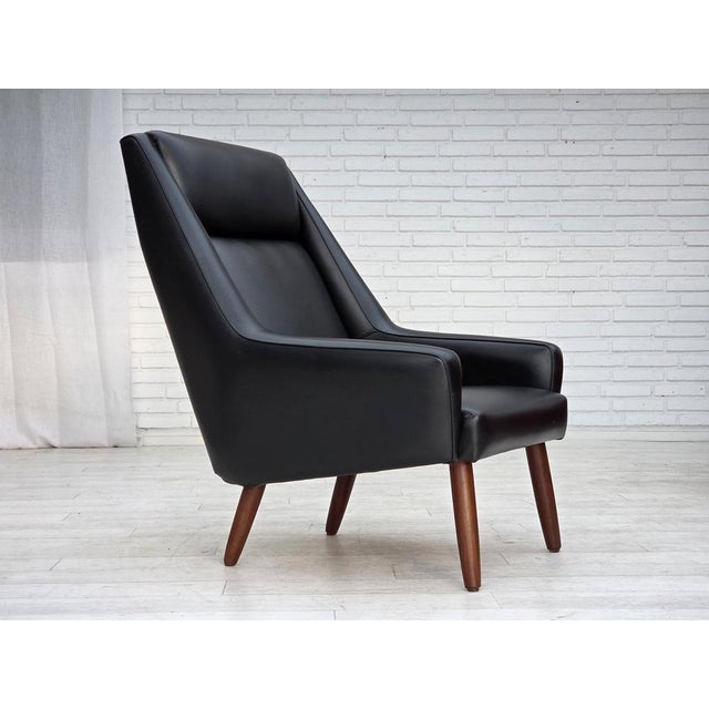 1970s, Danish armchair. Original black artificial leather, teak wood legs, springs in the seat. Original good condition:...