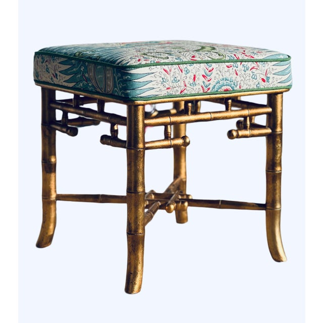 Giltwood faux bamboo bench with intricate fretwork frame. Gold painted finish with carved bell detailing. Newly...