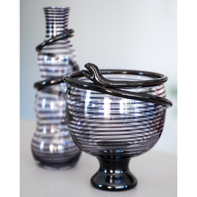 Matched two-piece “Cleopatra” glass ensemble designed by Ulrica Hydman-Vallien for Kosta Boda, comprising a tall carafe...