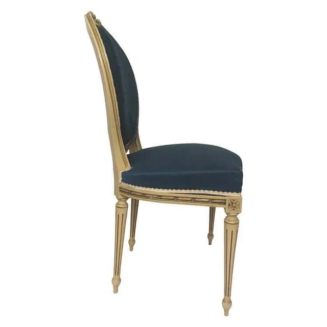 Louis XVI style medallion chair in painted wood and with blue silk upholstery. Fluted legs and typical decoration of the...