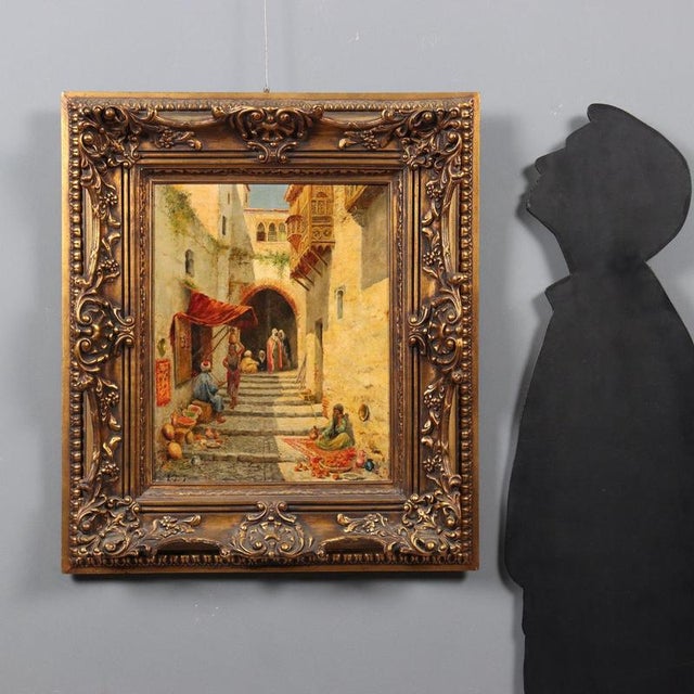 Oil on canvas. Unidentified signature at lower left. Orientalist subject, depicting a glimpse of an Arab street with fruit...