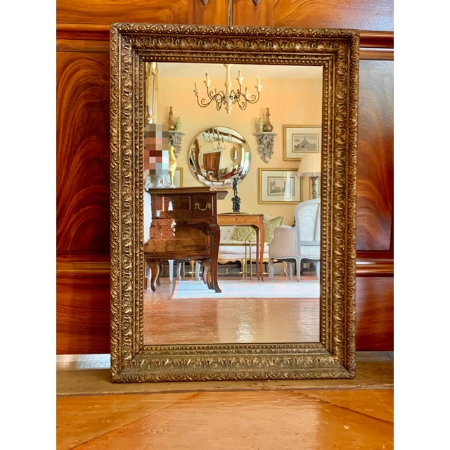 A handsome American mirror, the frame articulated with rows of composition moldings. Composition decoration was made of...