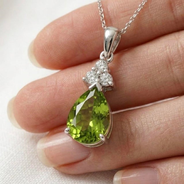 This vibrant pendant features a refreshing Peridot, a gemstone celebrated for its lively lime-green hue and natural...