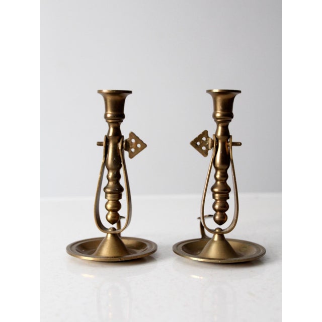 This is a pair of antique brass chambersticks. The candlestick holders tilt for safety and can be positioned and tightened...
