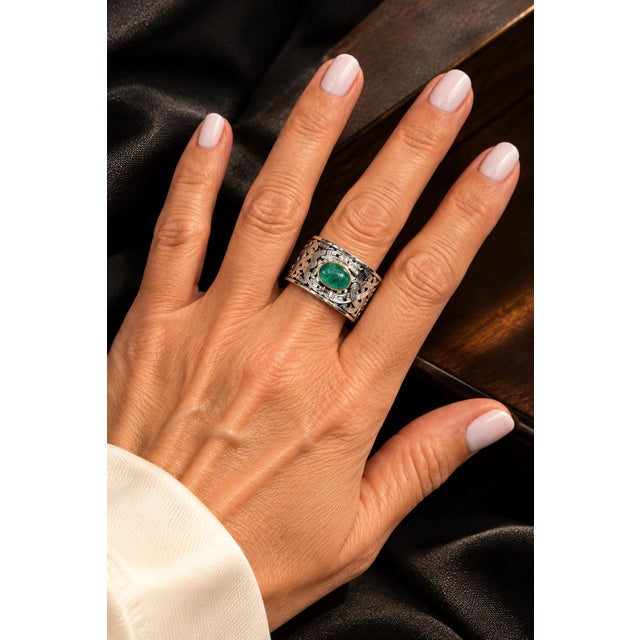 Vintage statement ring crafted in 14 karat white gold and centered with a natural emerald cabochon measuring approximately...