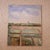 20th Century French Farmland Painting featuring a soft, atmospheric view of cultivated fields divided by narrow pathways...