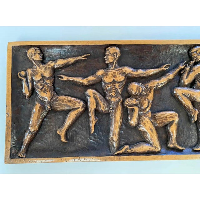 This striking mid-century modern carved wood wall relief depicts a procession of nude Greco-Roman–inspired athletes...