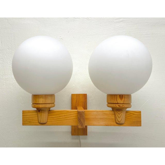 A double Swedish Modern Pine wood Wall lamp with white opaline glass shades made by Aneta in the 1970s. Good quality pine...