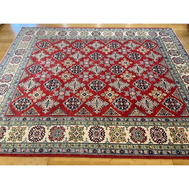 This is a Caucasian Kazak Lori Pambak-style rug, easily recognized by its rich red field, scattered tribal medallions, and...