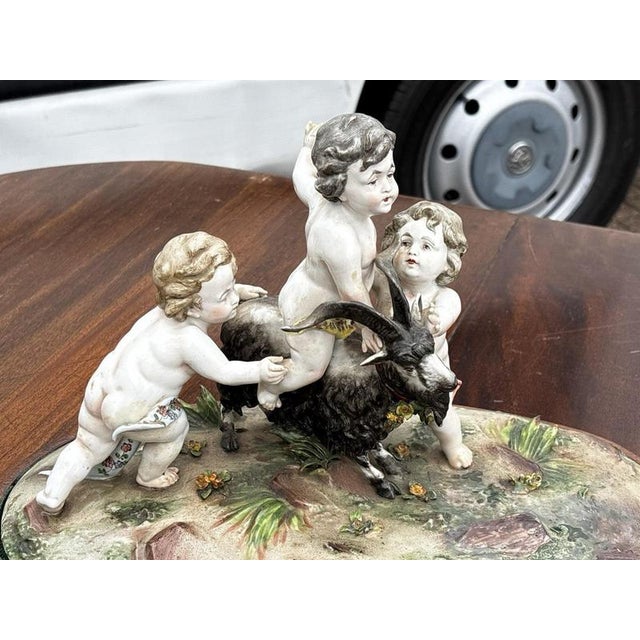 Porcelain Group Of Putti & The Goat Amalthea On Wooden Display Stand Sizes :- 40 cms wide, 25 cms tall, 22 cms depth In...