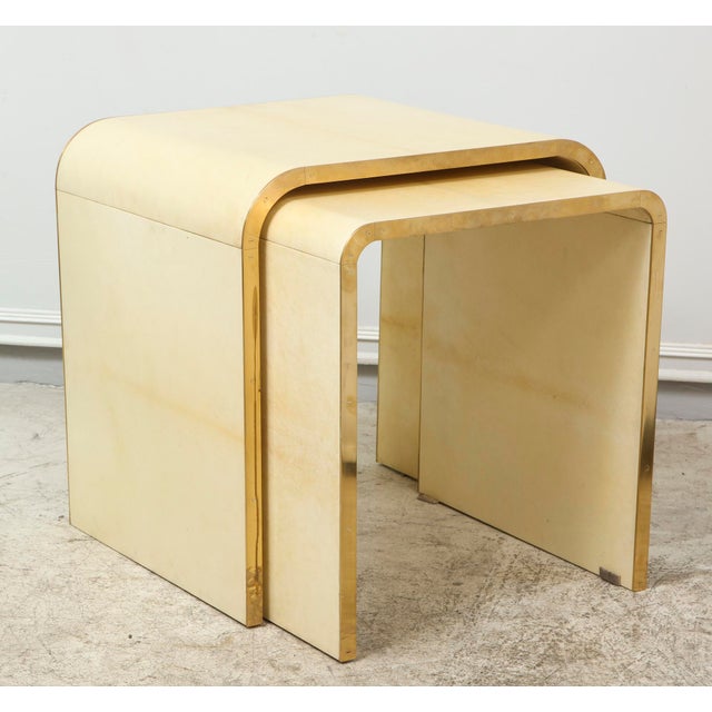 A set of two Bespoke parchment nesting tables with bronze banding. Larger Table measures: H 19.5" x W 18 3/4" x D 16.5"...