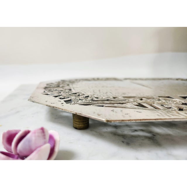 This is a beautiful and ornate example of a late 19th-century silver-plated expandable trivet by the Middletown Silverware...