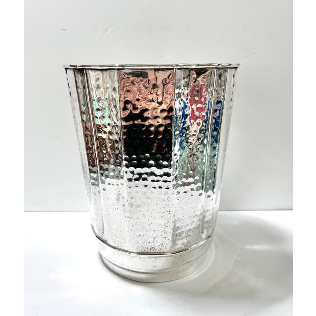 A stunning silver-plated wastebasket with a hammered finish. It has a scalloped flared rim. For a trash receptacle, it’s...