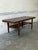 This long rectangular coffee table features a minimalist profile defined by clean lines. A built-in lower shelf offers a...