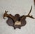 A midcentury deer antler trophy mounted on a dark-stained wood shield plaque. The plaque has chip carving and notched...