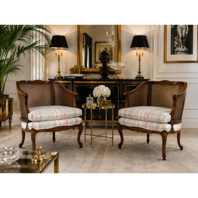 Elegant pair of 1960s vintage French Provincial club chairs in the Louis XV style, featuring beautifully carved walnut...