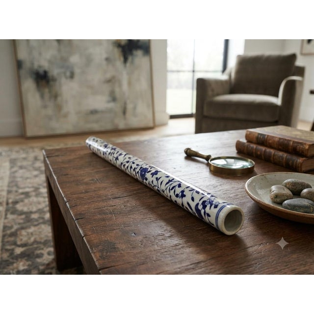 This exquisite blue and white porcelain display art piece features a slender, flute-shaped tubular silhouette adorned with...