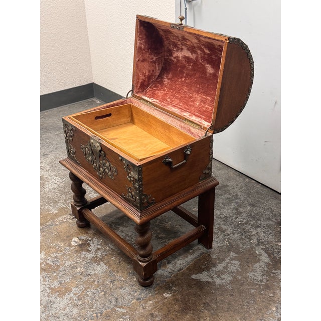 Design Plus Gallery presents an Antique Spanish Baroque Oak Trunk + Stand. The domed lid and rectangular body are...