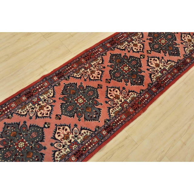 An authentic vintage traditional Roodbar runner hand-knotted with fine wool and natural dyes. This oriental rug features a...