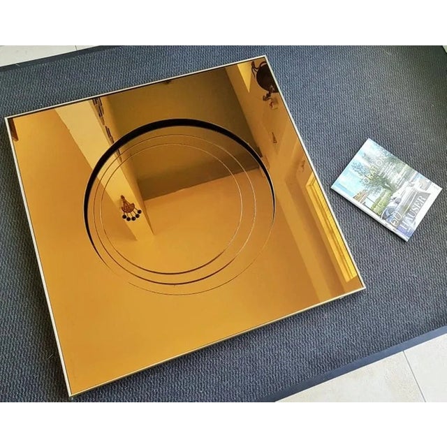 This great mid-century bronze glass mirror in the style of Fontana Arte was made in Italy in the 1960s. This piece has an...