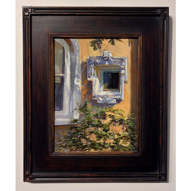 Garden Shadows captures a serene moment where light and shadow dance across a textured wall adorned with an ornate mirror....