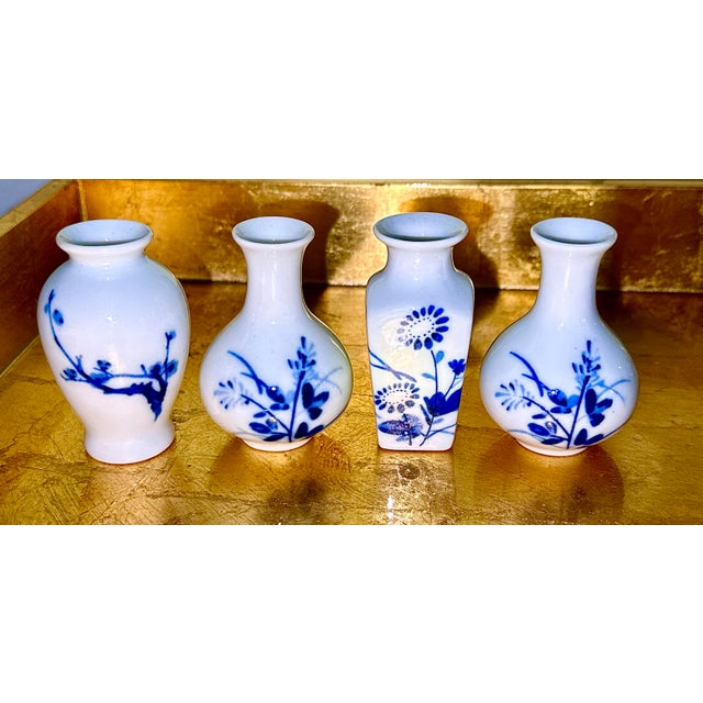 A beautiful set of 4 blue and white petite Chinese vases. Delicate blue floral patterns painted on white porcelain adorn...