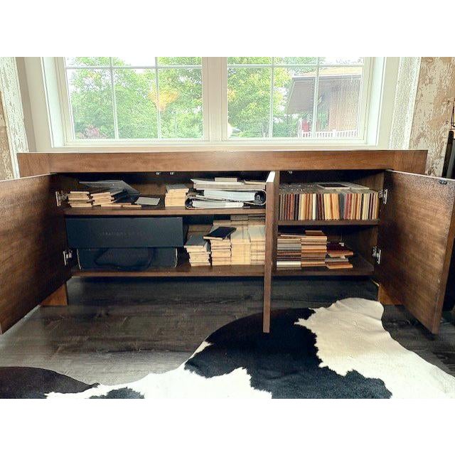 A mid-century inspired walnut credenza by Cisco Brothers. This credenza features two adjustable interior shelves in each...