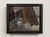 This oil on panel work depicts a simple white pitcher positioned beside weathered wooden planks, set against a softly lit...