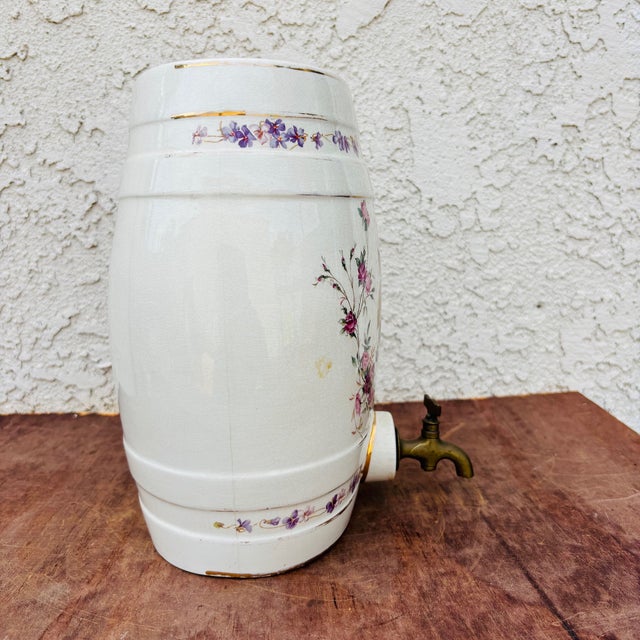 An elegant antique English ceramic spirit barrel, featuring hand-colored transferware decoration with fruit and floral...